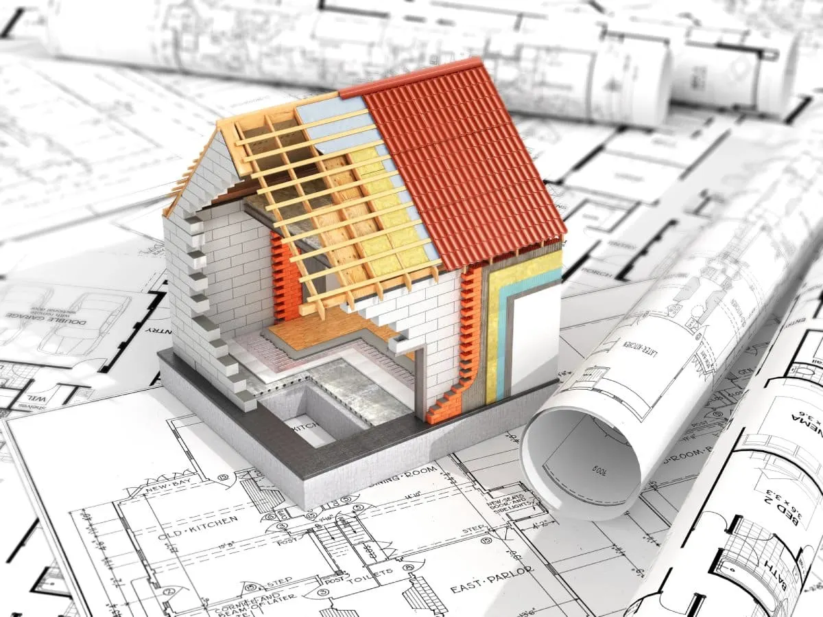 Cutaway house model set on architectural drawings